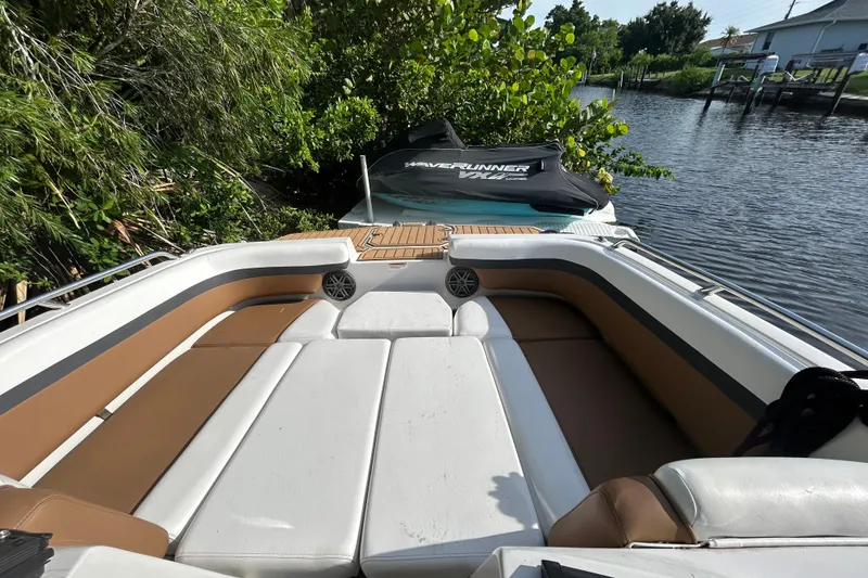 Slide: The Image of 2023 Starcraft SVX 191 OB boat interior with cushioned seating by a riverside. - 7
