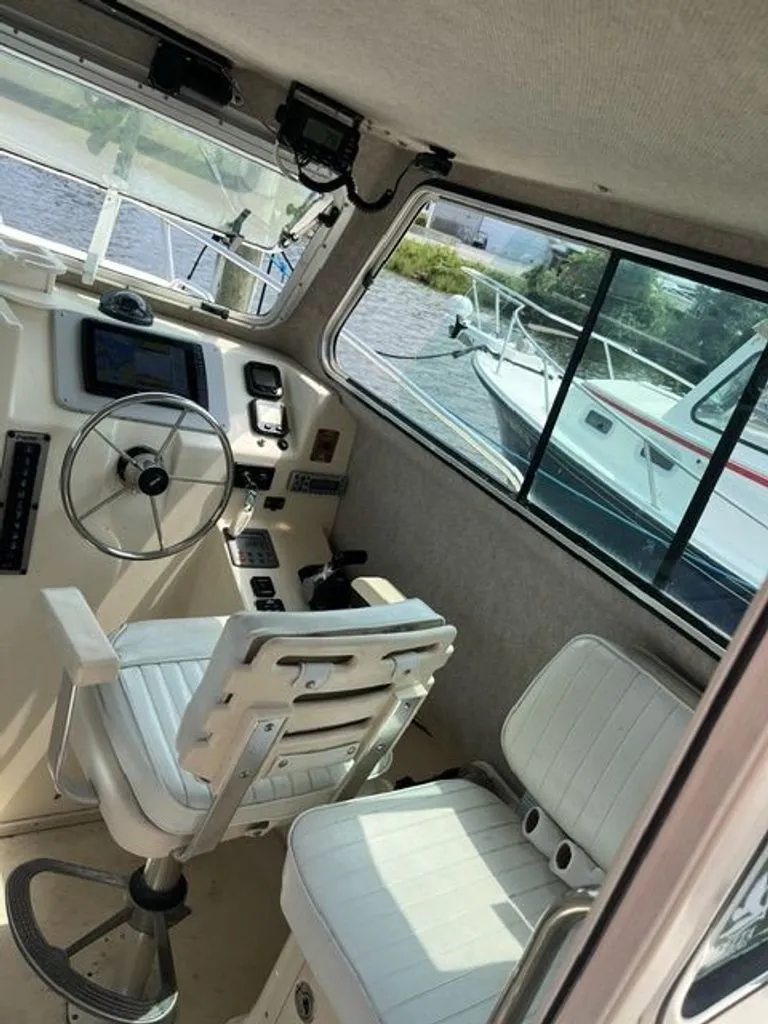 Slide: The Image of Interior view of a 2011 Parker 2520 XL Sport Cabin with helm and seating. - 6