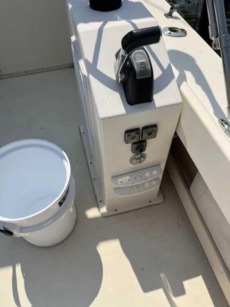 Slide: The Image of The image shows the cockpit of a 2011 Parker 2520 XL Sport Cabin boat with a control lever and a white bucket. - 11