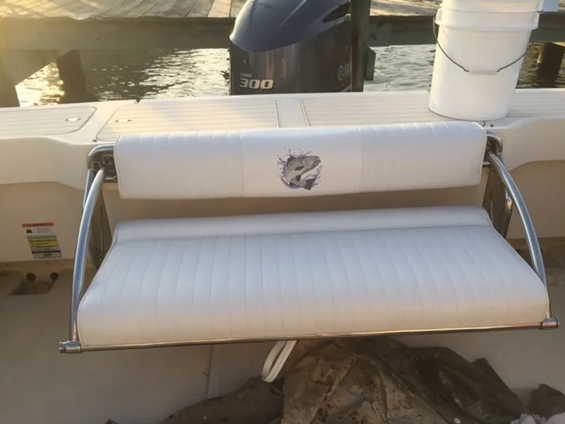 Slide: The Image of A white bench seat with a fish motif on a boat, with an engine in the background. - 12