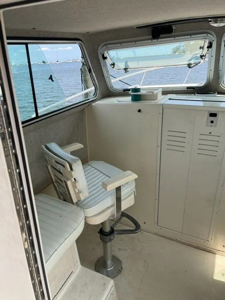 Slide: The Image of Interior of a 2011 Parker 2520 XL Sport Cabin with a white seat and a window view. - 8