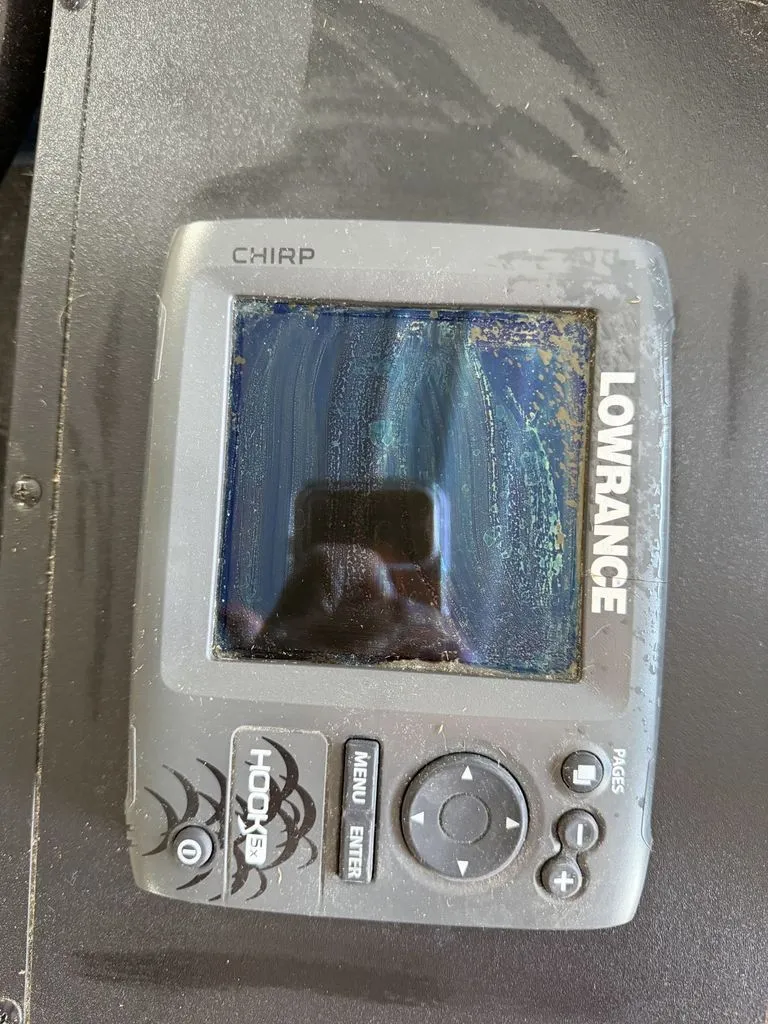 Slide: The Image of A Lowrance fish finder with CHIRP technology, mounted on a boat, showing signs of use. - 11