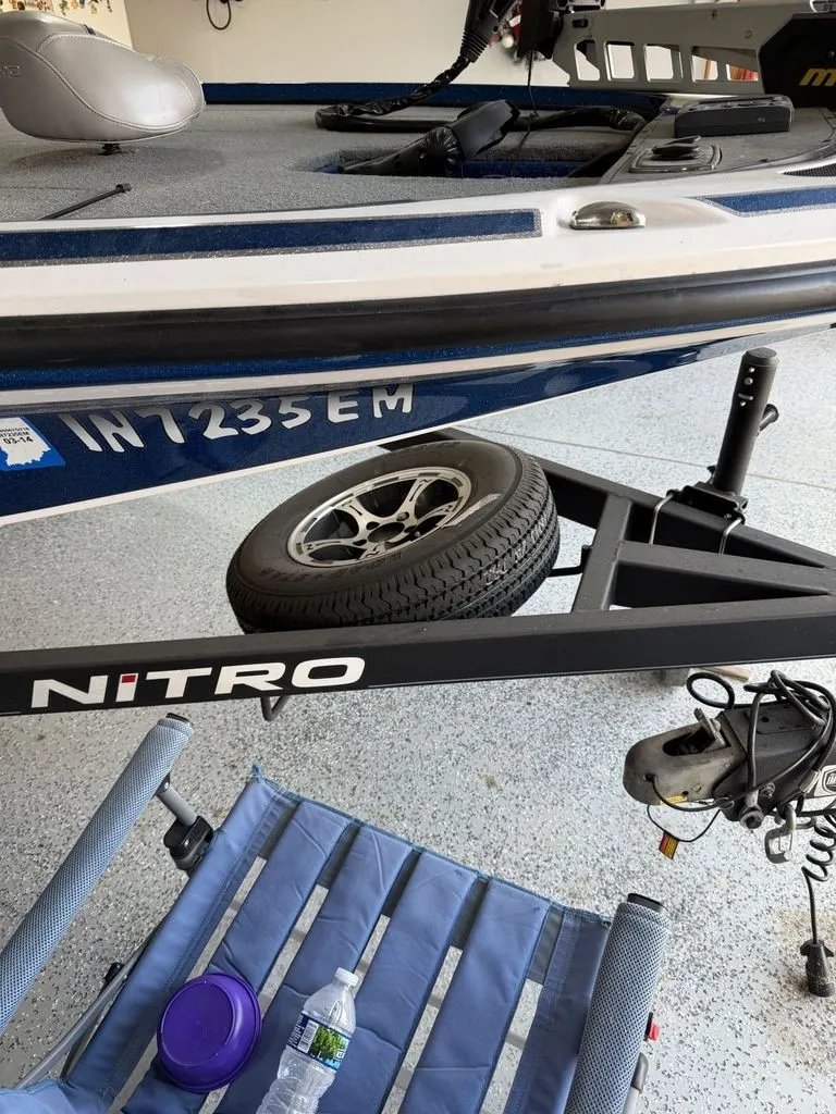 Slide: The Image of A 2018 Nitro Z18 boat on a trailer with a spare tire and a blue seating area. - 20