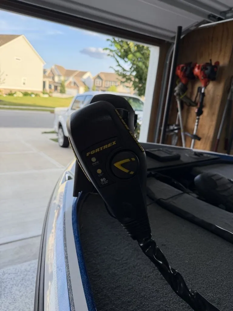 Slide: The Image of Close-up of a boat motor in a garage, with houses in the background. - 2