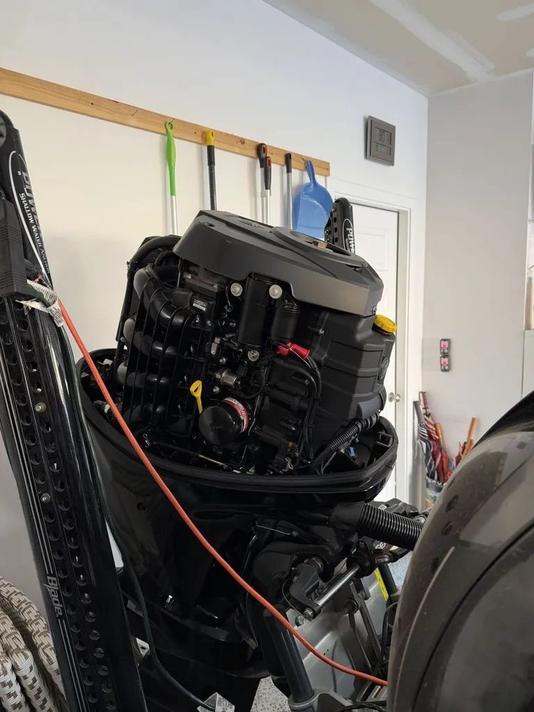 Slide: The Image of An outboard motor in a garage, surrounded by tools and equipment. - 27