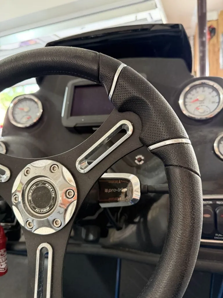 Slide: The Image of The image shows the steering wheel and dashboard of a 2018 Nitro Z18 boat. - 8
