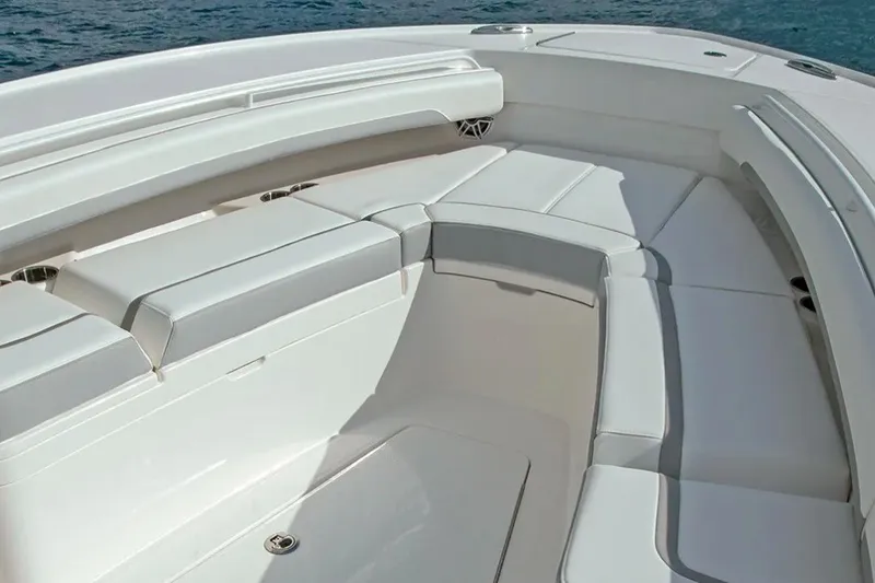 Slide: The Image of 2027 Regulator 28 Forward Seating boat with spacious, cushioned seating area on calm water. - 2