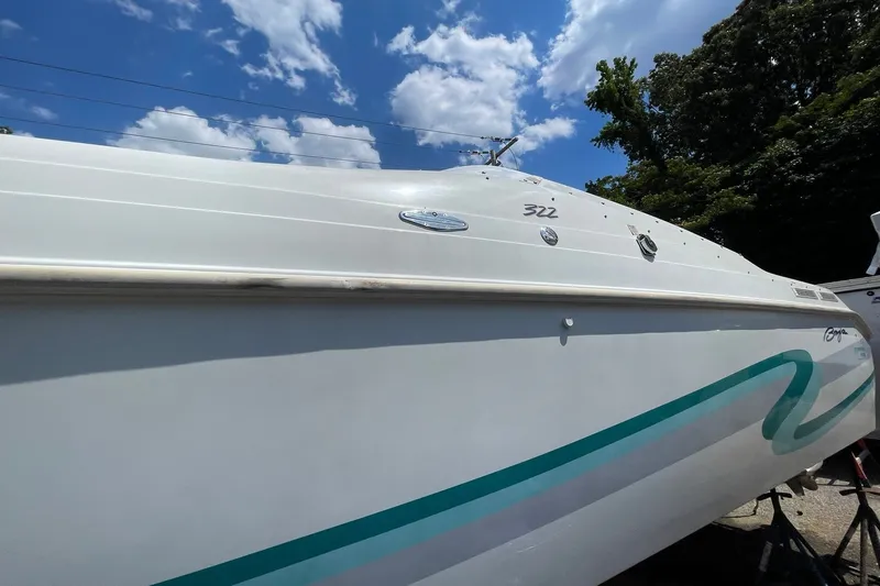 Slide: The Image of 1996 Baja 322 boat under a clear blue sky with white clouds. - 18