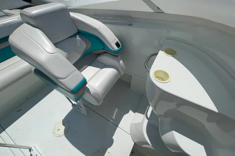 Slide: The Image of Interior of a 1996 Baja 322 boat featuring white and teal seating with cup holders. - 10