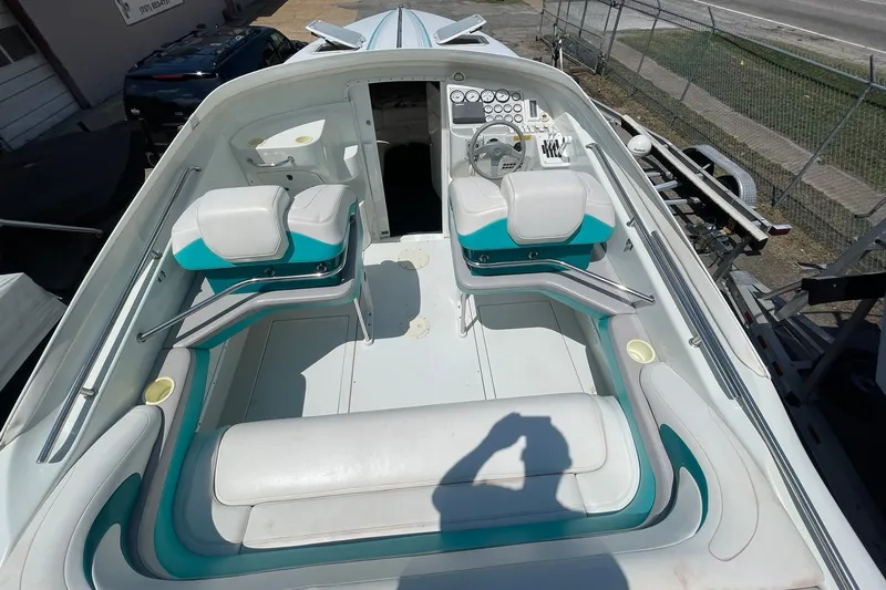 Slide: The Image of 1996 Baja 322 boat interior with white and teal seating, steering wheel, and dashboard. - 3