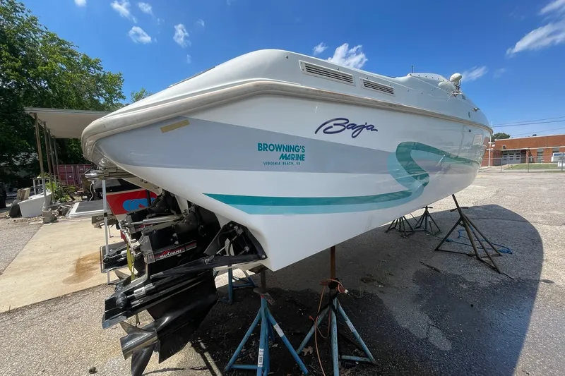 Slide: The Image of 1996 Baja 322 boat on stands, featuring sleek design and vibrant graphics under a clear sky. - 13