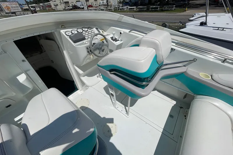 Slide: The Image of 1996 Baja 322 boat interior with white and teal seating, steering wheel, and dashboard gauges. - 7