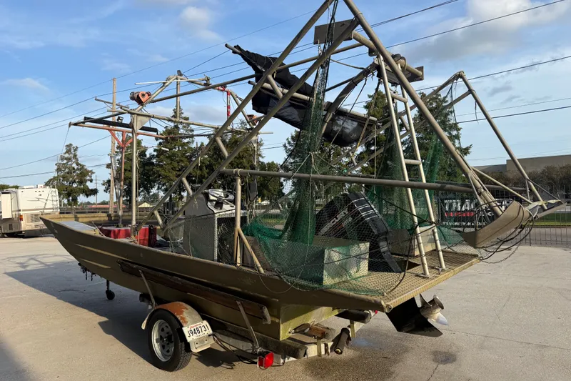 Slide: The Image of 1984 Alweld 1852PF boat with netting and equipment on a trailer. - 5