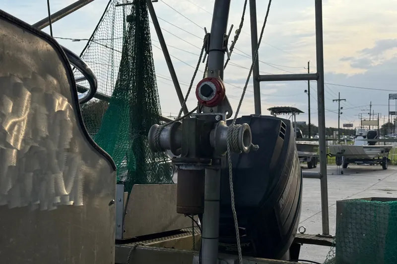 Slide: The Image of 1984 Alweld 1852PF boat with motor and fishing net, docked at marina. - 10
