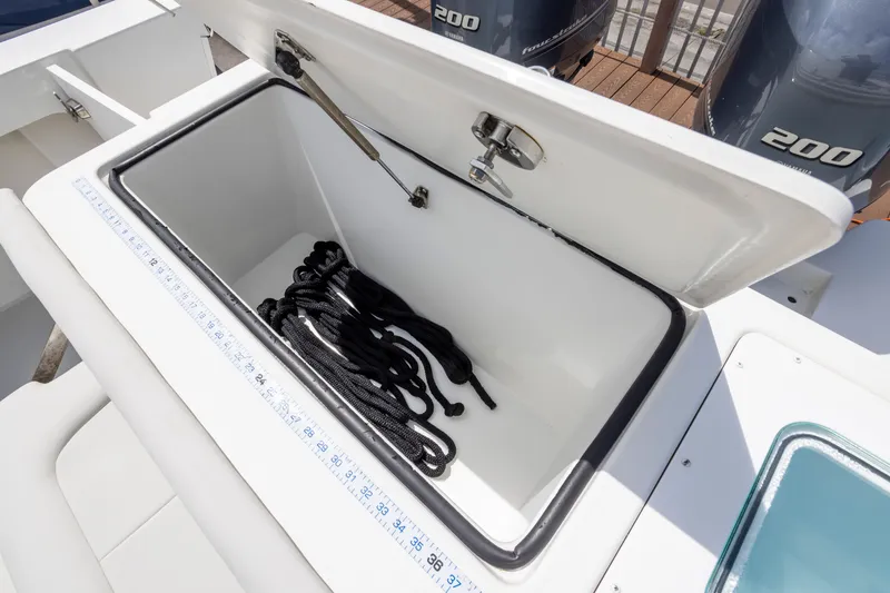 Slide: The Image of Open storage compartment on 2022 Parker 2600 Center Console boat with black rope inside. - 9