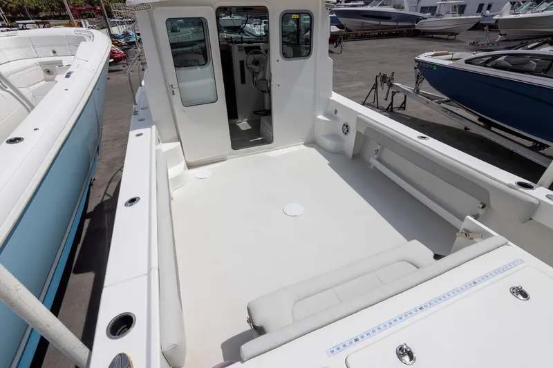 Slide: The Image of 2022 Parker 2600 Center Console boat with spacious deck and seating, docked among other boats. - 10