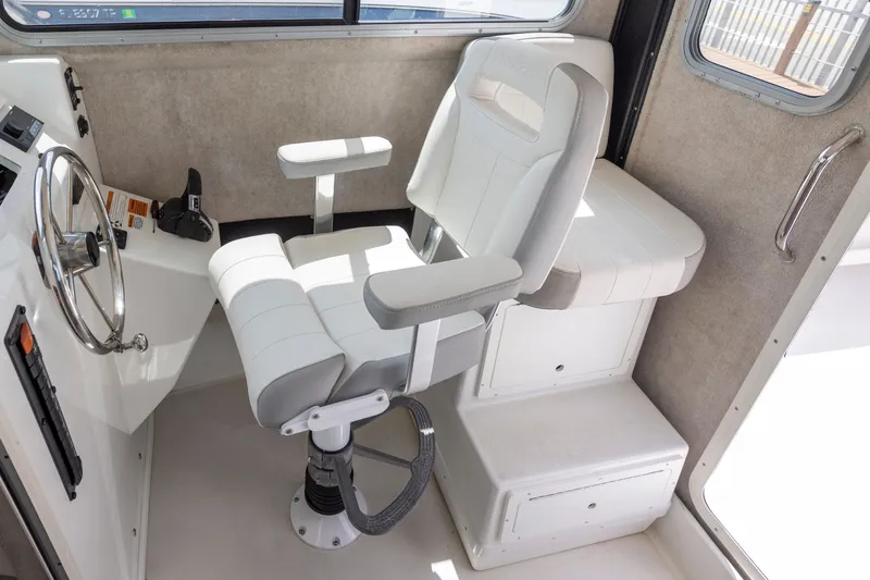 Slide: The Image of Captain's chair in 2022 Parker 2600 Center Console boat cockpit, featuring modern design and controls. - 14