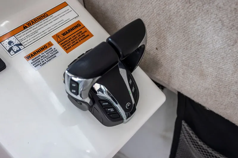 Slide: The Image of Throttle controls on a 2022 Parker 2600 Center Console boat with warning labels. - 16