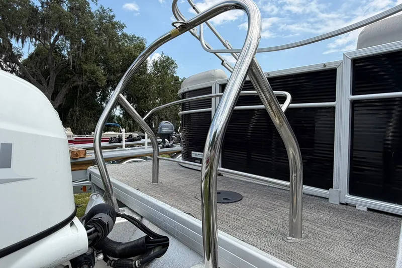 Slide: The Image of 2022 Sweetwater 2286 SBX pontoon boat with stainless steel railings and outboard motor. - 6