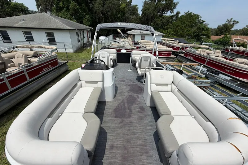 Slide: The Image of 2022 Sweetwater 2286 SBX pontoon boat with spacious seating and canopy, parked outdoors. - 8