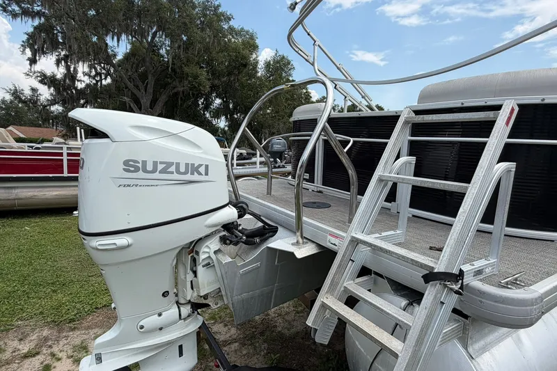 Slide: The Image of 2022 Sweetwater 2286 SBX pontoon boat with Suzuki outboard motor and boarding ladder. - 5