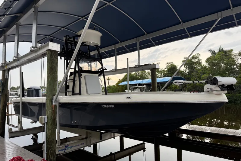Slide: The Image of 2021 Skeeter SX2550 Fish boat on lift under canopy, docked by water. - 1