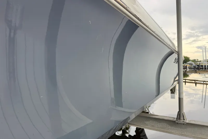 Slide: The Image of 2021 Skeeter SX2550 Fish boat hull reflecting water and sky at dock. - 5