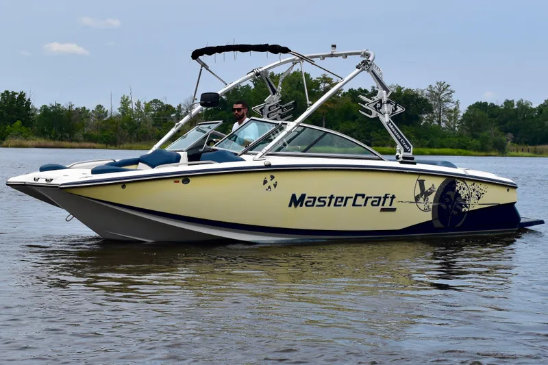 The Image of 2010 MasterCraft X-35 SS boat on calm water, featuring sleek design and wakeboard tower. - 0