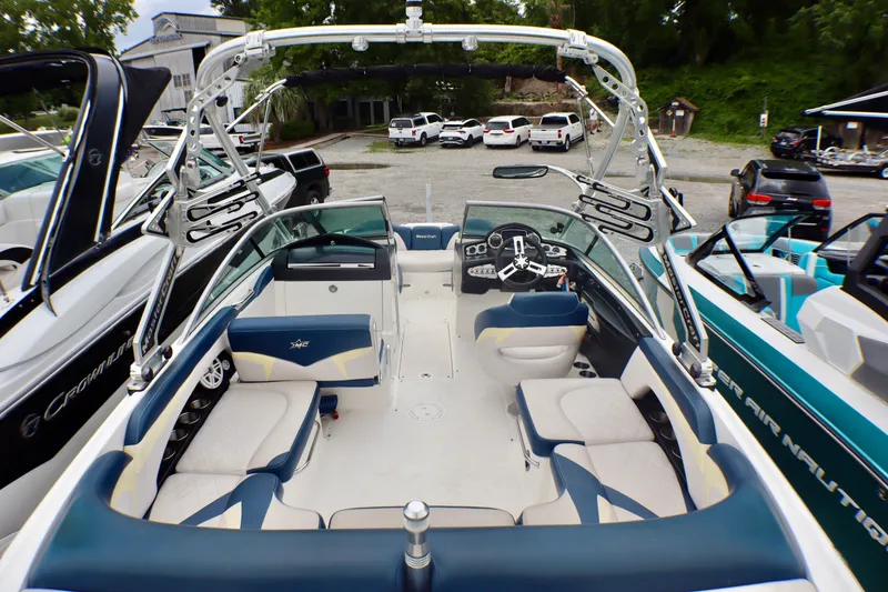 Slide: The Image of 2010 MasterCraft X-35 SS boat interior with blue and white seating, docked at marina. - 24