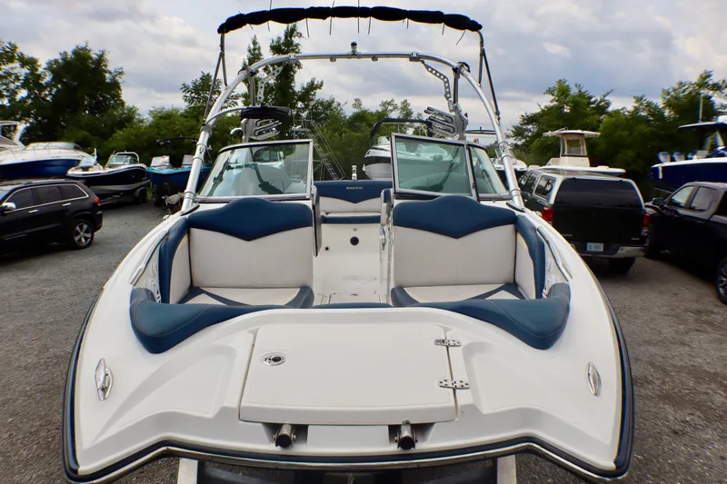 Slide: The Image of 2010 MasterCraft X-35 SS boat with blue and white seating, parked outdoors. - 9