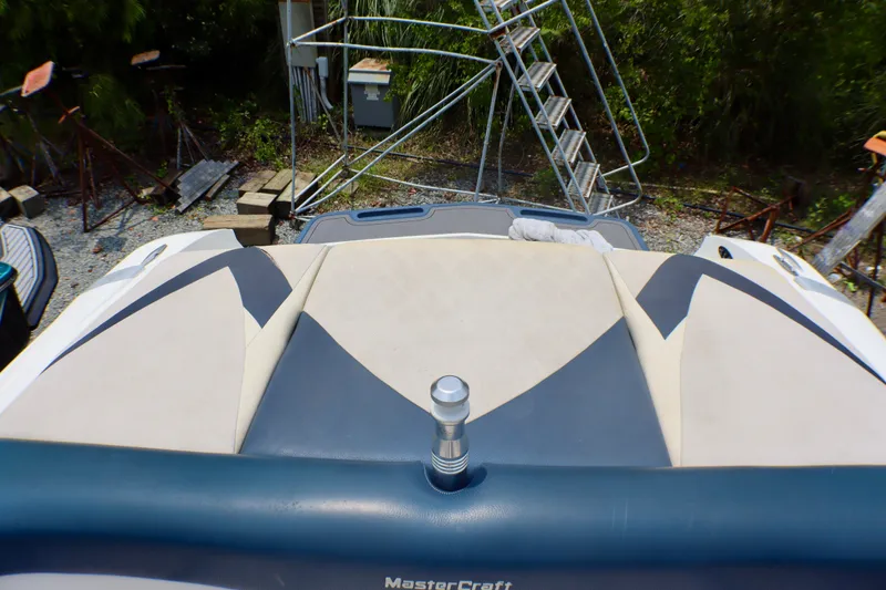 Slide: The Image of 2010 MasterCraft X-35 SS boat interior with cushioned seating and outdoor background. - 22