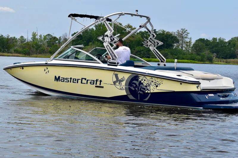 Slide: The Image of 2010 MasterCraft X-35 SS boat on a calm lake, featuring sleek design and vibrant graphics. - 38