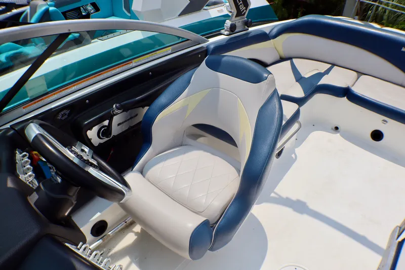 Slide: The Image of 2010 MasterCraft X-35 SS boat interior with blue and white seating and steering wheel. - 14