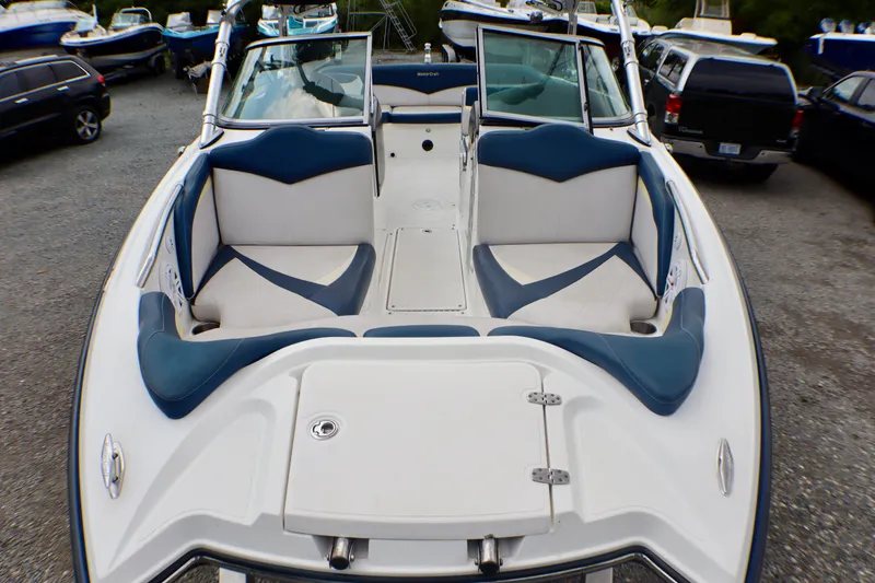 Slide: The Image of 2010 MasterCraft X-35 SS boat interior with blue and white seating, parked outdoors. - 27