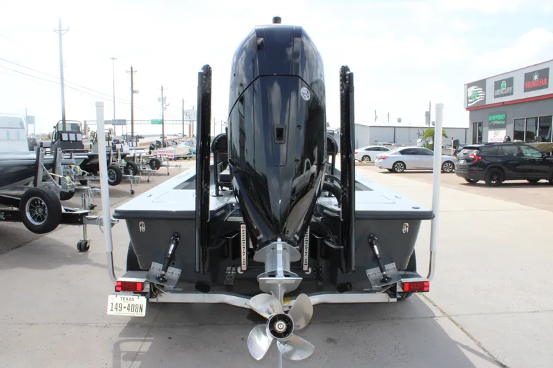 Slide: The Image of 2025 Mamba 24VX boat with powerful outboard motor, parked in dealership lot. - 19
