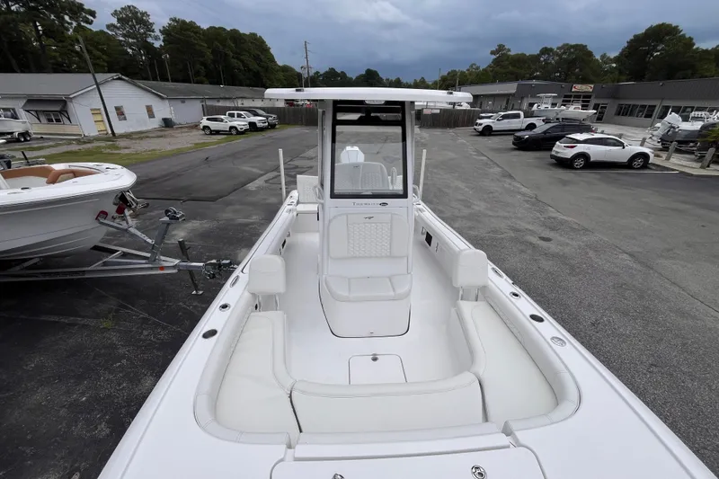 Slide: The Image of 2027 Tidewater 2500 Carolina Bay boat with spacious seating, parked outdoors. - 12