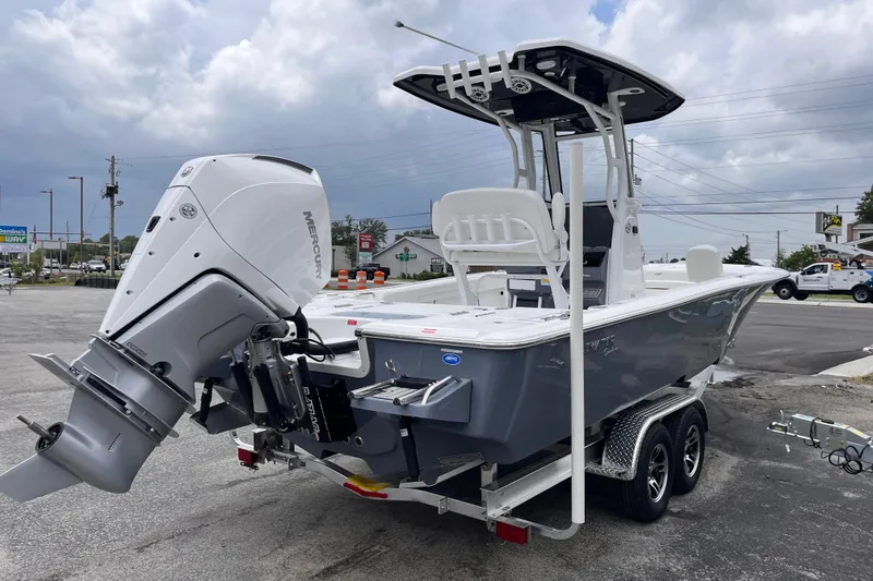 Slide: The Image of 2027 Tidewater 2500 Carolina Bay boat with Mercury engine on trailer, parked outdoors. - 4