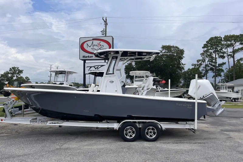 The Image of 2027 Tidewater 2500 Carolina Bay boat on trailer at dealership, overcast sky. - 0