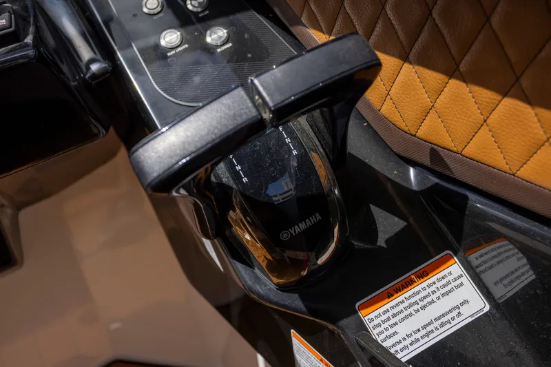 Slide: The Image of 2024 Yamaha Boats 275SE throttle control and dashboard detail with warning label. - 12