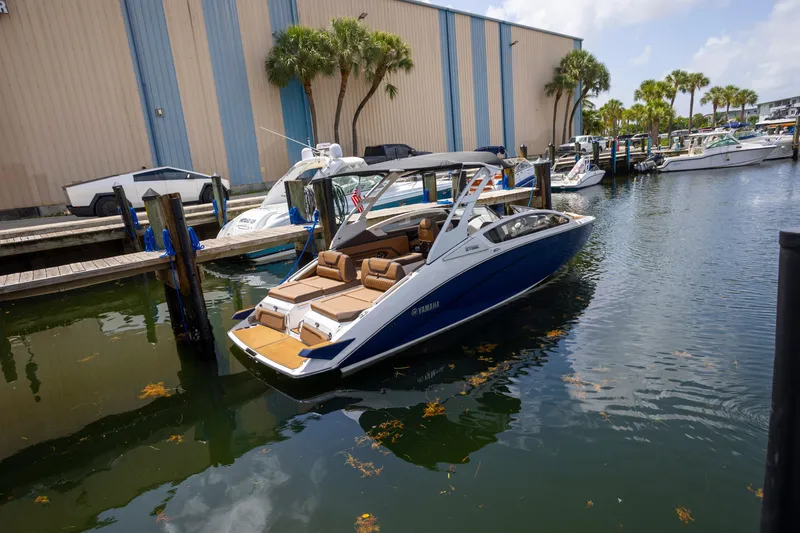 The Image of 2024 Yamaha Boats 275SE docked in marina, surrounded by palm trees and other boats. - 1