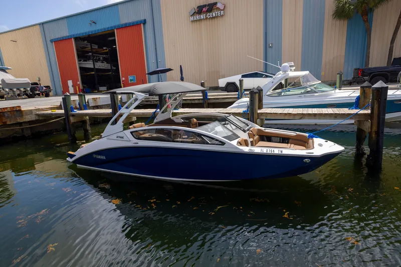Slide: The Image of 2024 Yamaha Boats 275SE docked at a marina, showcasing sleek design and modern features. - 19