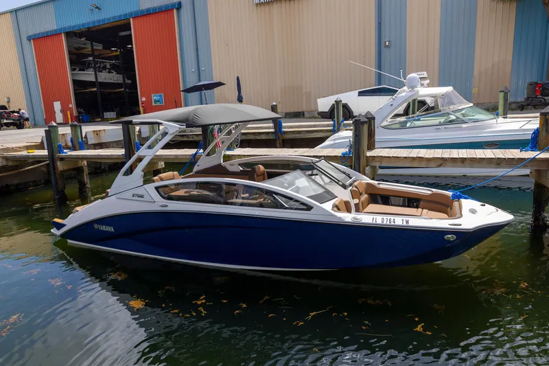 Slide: The Image of 2024 Yamaha Boats 275SE docked at marina, featuring sleek design and blue exterior. - 18