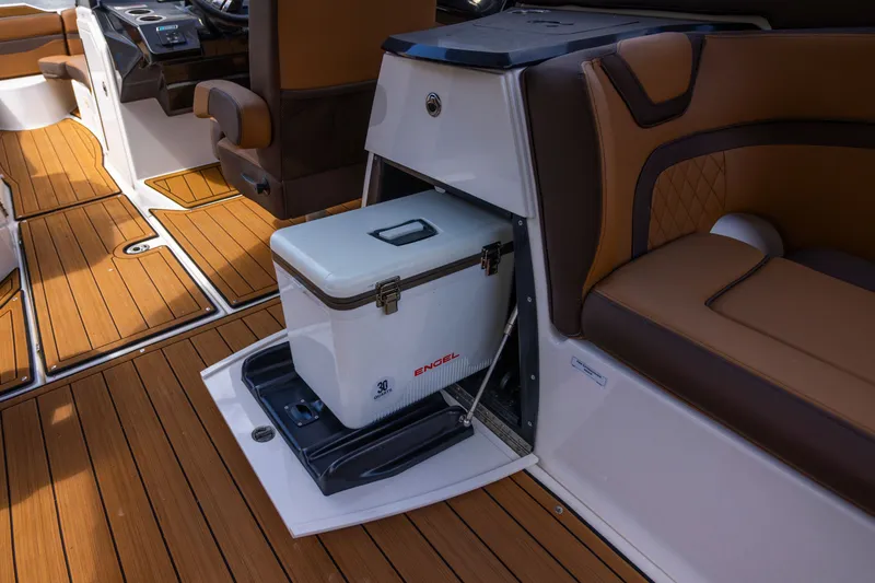 Slide: The Image of 2024 Yamaha Boats 275SE interior with Engel cooler and luxurious seating on teak flooring. - 9