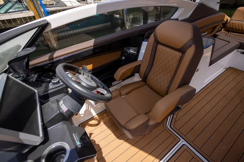 Slide: The Image of 2024 Yamaha Boats 275SE cockpit with luxurious seating and modern steering wheel design. - 4