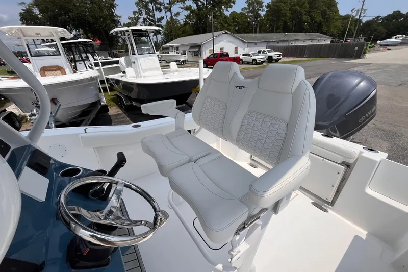Slide: The Image of 2027 Tidewater 232 CC Adventure boat with sleek white seating and modern steering wheel. - 13