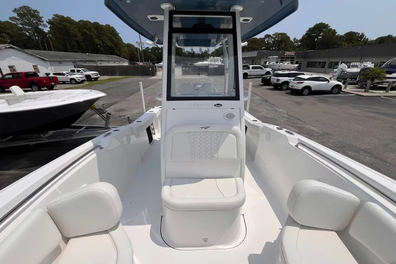 Slide: The Image of 2027 Tidewater 232 CC Adventure boat with white seating, parked in a dealership lot. - 10
