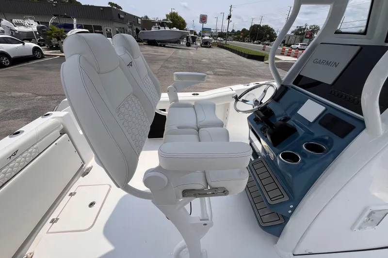 Slide: The Image of 2027 Tidewater 232 CC Adventure boat interior with Garmin navigation and white seating. - 6