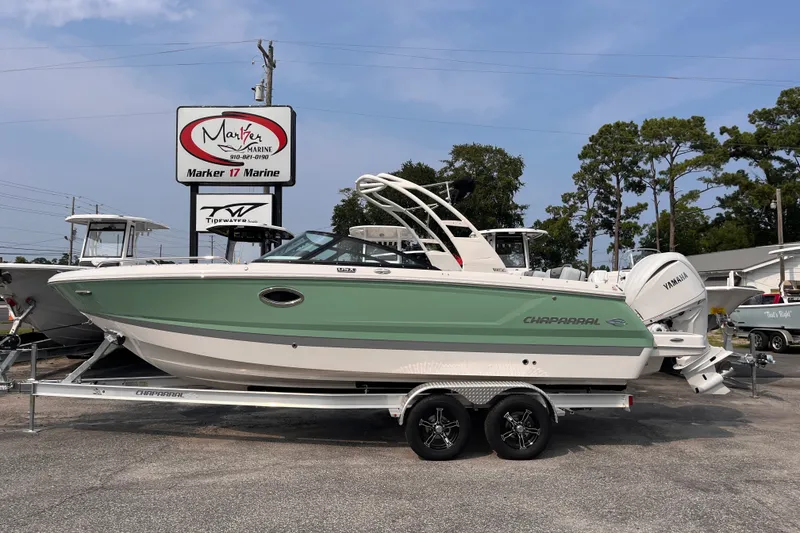 The Image of A 2025 Chaparral 250 OSX boat on a trailer in front of a boat dealership. - 1