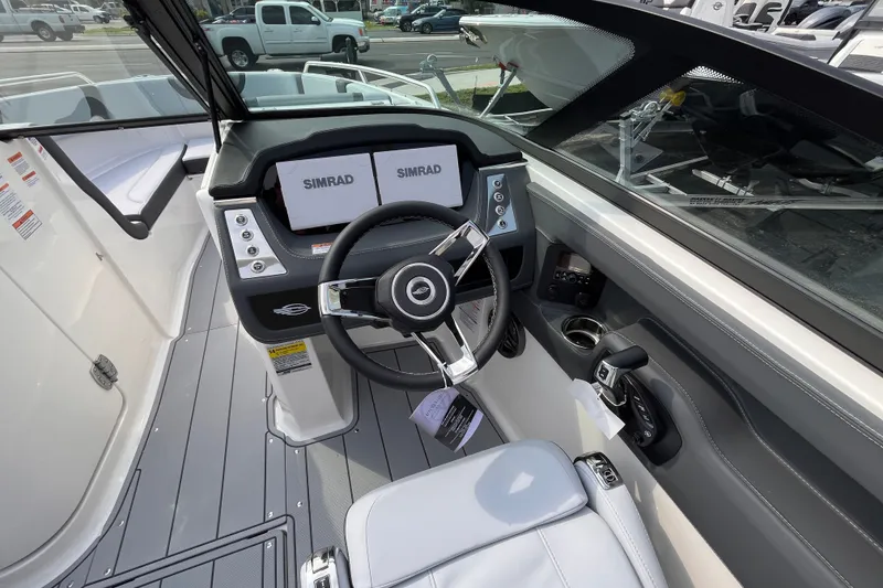 Slide: The Image of Chaparral 250 OSX 2025: Modern cockpit with Simrad displays, gray flooring, and a comfortable seat. - 12
