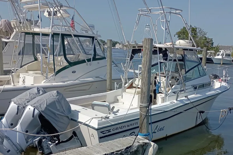 Slide: The Image of 1993 Grady-White Dolphin 250 boat docked at marina, featuring dual outboard motors. - 4